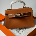 Hermes Kelly brown leather handbag in orange box, ideal for women.