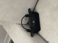 Black Longchamp Le Pliage XS handbag on beige sofa.