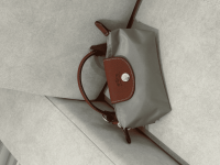 Longchamp Le Pliage XS handbag on grey surface.