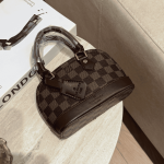 Çanta femrash Louis Vuitton Alma Mini e vendosur mbi një tavolinë mermeri.