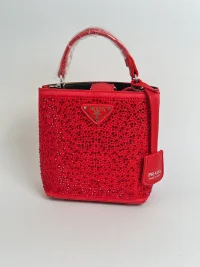 Red beaded women's handbag with handle and logo.