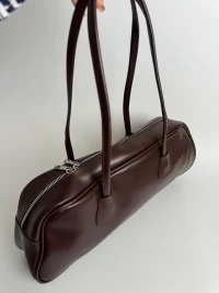 Elegant brown women's handbag with long handles and zipper closure.