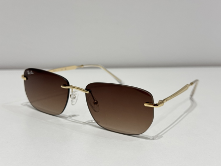 Syze dielli Ray-Ban me kornizë të artë dhe lente kafe për stil dhe mbrojtje.