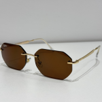 Syze dielli Ray-Ban me lente kafe dhe kornizë të artë.