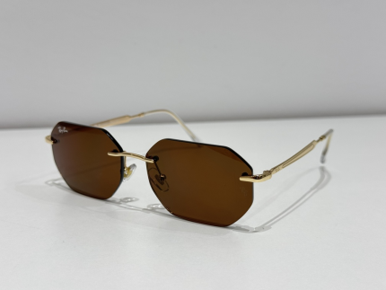 Syze dielli Ray-Ban me lente kafe dhe kornizë të artë.