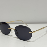 Syze dielli Ray-Ban me kornizë të artë dhe lente të errëta për mbrojtje dhe stil.