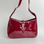 YSL Hobo, çanta e kuqe me ndriçim të shkëlqyer dhe detaje në ar.