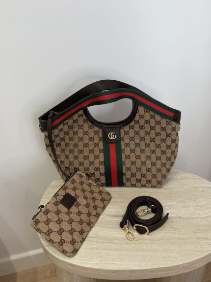 Gucci Ophidia GG shoulder bag with pouch and strap on table.