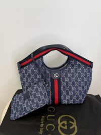 Gucci Ophidia GG shoulder bag with iconic pattern and red stripe.