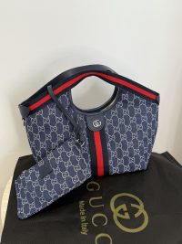 Gucci Ophidia GG shoulder bag with iconic monogram and red stripe.