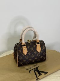 Louis Vuitton Speedy Bandouliere mini bag with monogram design on dust bag.