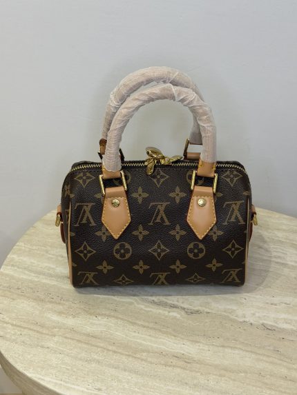 Louis Vuitton Speedy Bandouliere mini handbag on marble surface.
