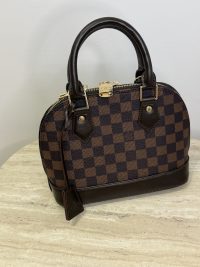 Louis Vuitton Alma BB handbag with shoulder strap, checkered pattern.