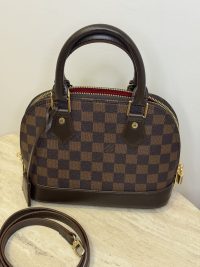 Louis Vuitton Alma BB handbag with shoulder strap, checkered pattern.