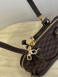 Louis Vuitton Alma BB shoulder bag with checkered design and gold accents.
