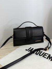 Black Jacquemus Le Bambino bag on white surface.