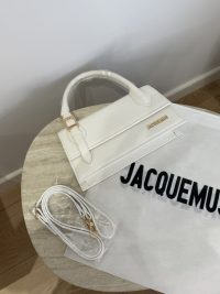 White Jacquemus Le Chiquito Long handbag on table with strap and dust bag.