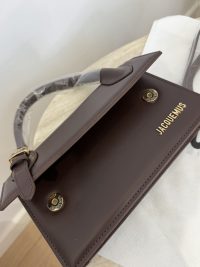 Canta Jacquemus Le Chiquito Long brown handbag on table.