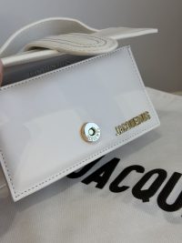 White Jacquemus Le Bambino mini bag on branded fabric.
