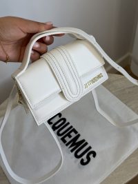 White Jacquemus Le Bambino mini bag with logo and strap.