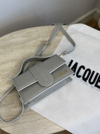 Gray Jacquemus Le Bambino mini bag on marble table.