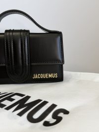 Black Jacquemus Le Bambino mini bag on branded dust bag.