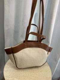 Canvas tote bag with leather straps on display.