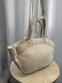 Beige university bag with leather straps on display.