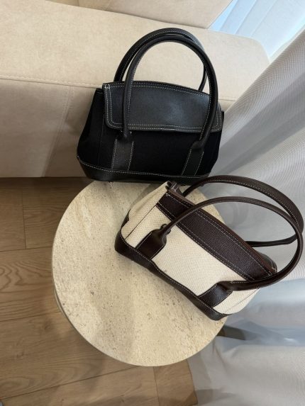 Canvas leather handbags on round table, elegant and comfortable design.