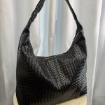 Elegant black woven leather hobo bag on display.