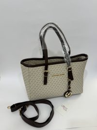 Michael Kors beige tote bag with brown straps and logo charm.