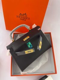 Hermès Mini Kelly black handbag in orange box with gold hardware.