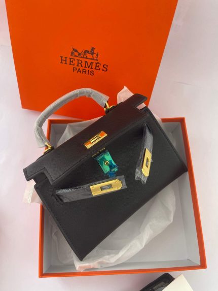 Hermès Mini Kelly black handbag in orange box with gold hardware.