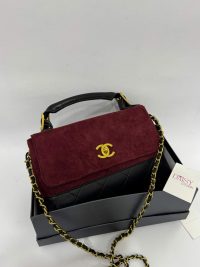 Chanel Flap suede handbag with gold chain on display box.