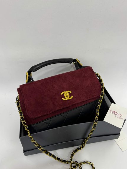 Chanel Flap suede handbag with gold chain on display box.