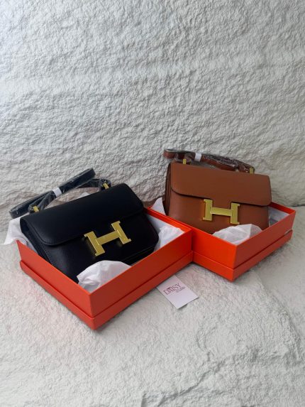 Hermès Constance bags in boxes, black and brown, for women.