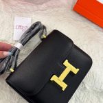 Hermès Constance black leather bag with gold hardware on display.