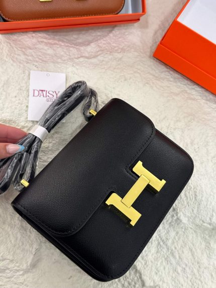 Hermès Constance black leather bag with gold hardware on display.