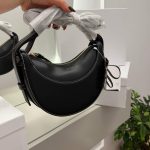 Black Polène Cyme Mini handbag displayed elegantly in hand.