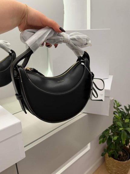 Black Polène Cyme Mini handbag displayed elegantly in hand.