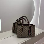 Gucci GG Supreme Tote bag on mirrored surface, elegant and functional design.