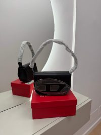 Elegant black Diesel handbag on red box, mirrored reflection.