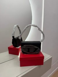 Diesel black handbag on red box, elegant design.