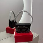 Elegant black Diesel handbag on red box, mirror reflection.