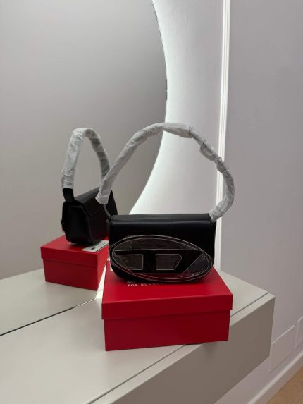Elegant black Diesel handbag on red box, mirror reflection.