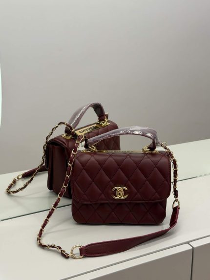 Chanel Trendy CC burgundy handbag with gold chain handle.