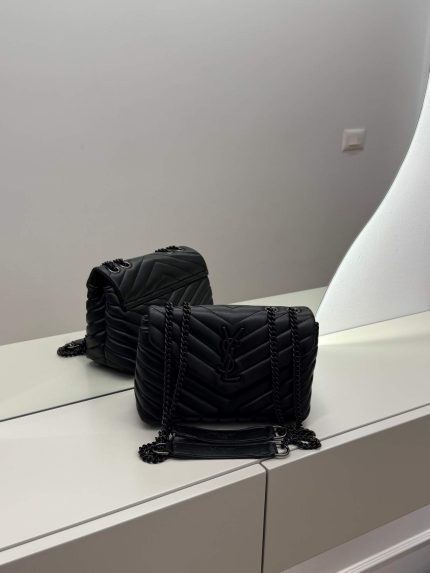 Black Saint Laurent Loulou bag with chain strap on mirror surface.