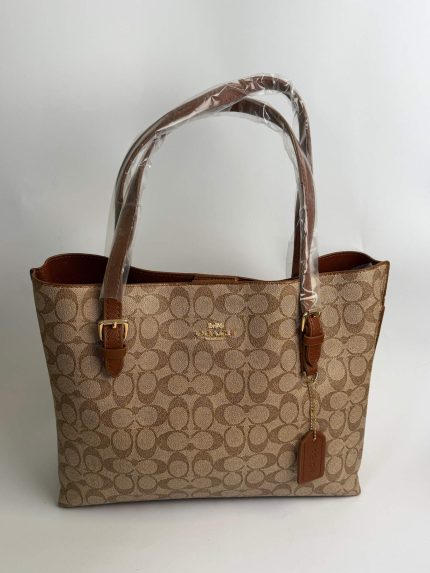 Coach Mollie Signature tote bag with brown leather straps.