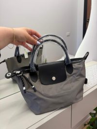 Gray Longchamp Le Pliage bag with black leather flap.
