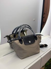 Çanta Longchamp Le Pliage, beige tote with black leather accents.